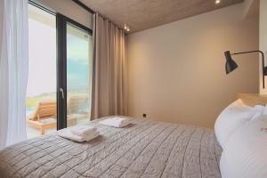 ein Schlafzimmer mit einem Bett mit zwei Handtüchern darauf in der Unterkunft Marelys Villa Nea Skioni by Halkidiki Villas in Nea Skioni + 8 Fotos