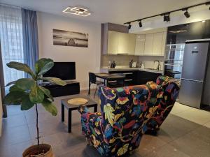 ein Wohnzimmer mit Couch und Küche in der Unterkunft Apartament Katowice Tysiąclecie in Kattowitz