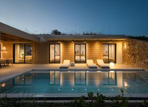 ein Haus mit Swimmingpool bei Nacht in der Unterkunft Marelys Villa Nea Skioni by Halkidiki Villas in Nea Skioni