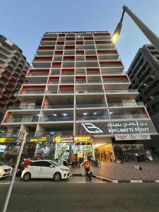 a tall building with cars parked in front of it at Sleek 1BR in DSO, Dubai in Dubai