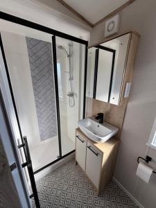 a bathroom with a sink and a shower at The Retreat 10 - Hot tub Mini Lodge, central heating, bed linen, & pet friendly - Meadow Lakes Caravan Hire in Chapel Saint Leonards