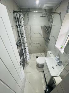 a white bathroom with a sink and a toilet at 93 New Road in Harmondsworth +46 photos