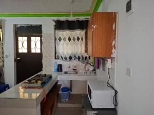 a small kitchen with a sink and a stove at Royal Studio Apartment in Mombasa +11 photos