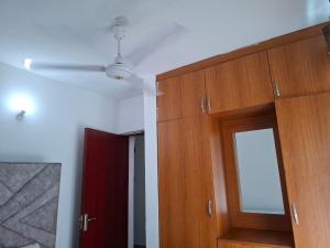 a room with a ceiling fan and a wooden door at Royal Studio Apartment in Mombasa