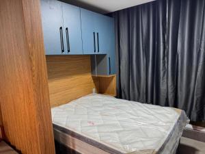 a small bedroom with a bed and blue cabinets at Loft in Xangri-lá