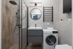 a bathroom with a washing machine and a sink at Baltic Waves Resort w Międzyzdrojach Blisko Plaży & Parking by Noclegi Renters in Międzyzdroje