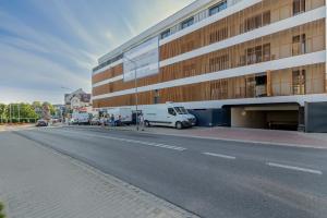 a white van parked in front of a building at Baltic Waves Resort w Międzyzdrojach Blisko Plaży & Parking by Noclegi Renters in Międzyzdroje