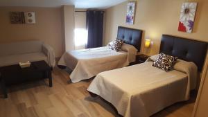 Łóżko lub łóżka w pokoju w obiekcie Hostal Málaga