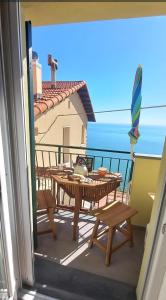 a balcony with a table and chairs and a view of the ocean at La casetta sul mare in San Bernardino