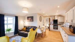 ヘクサムにあるThe Oak Apartmentのソファとテーブルのあるキッチンとリビングルーム