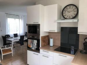 a kitchen with a clock on the wall and a table at ChicEthnik! Maison de ville, 3 chambres, 6 places. in Besançon +40 photos
