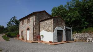 a small brick building with two doors and a wall at Agriturismo le Vallilunghe in Chiatri