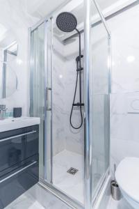 W łazience znajduje się prysznic ze szklanymi drzwiami. w obiekcie Home Suite Home Grands Boulevards 41 w Paryżu