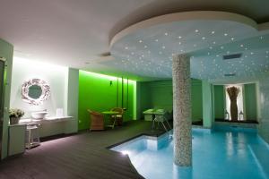 a swimming pool in a room with green walls at Litohoro Olympus Resort Villas & Spa in Plaka Litochorou