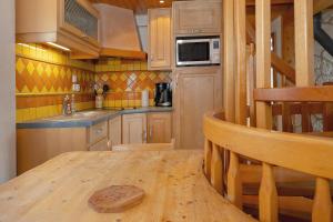 a kitchen with a wooden table and a microwave at Chalet 214 - Village nordique in Les Déserts
