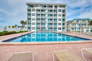 a swimming pool in front of a large building at Daytona Beach Condo with Ocean-View Balcony! in Daytona Beach