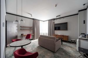 a living room with a couch and a table and chairs at Hotel Kossak in Kraków