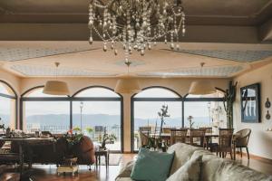a living room with a chandelier and large windows at Villa Vernazza in Castelnuovo Magra