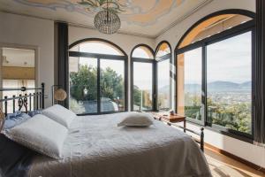 a bedroom with a large bed with large windows at Villa Vernazza in Castelnuovo Magra