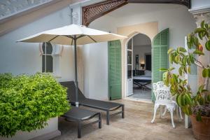 a patio with a table and an umbrella and chairs at La Villa Mauresque in Saint-Raphaël