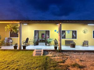 una casa amarilla con un patio y un jardín en Milagres, en São Miguel dos Milagres