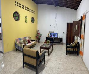 una sala de estar con sofás y TV. en Milagres, en São Miguel dos Milagres
