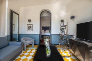 a living room with a couch and a tv at La Villa Mauresque in Saint-Raphaël