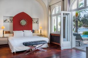 a bedroom with a large white bed with a red headboard at La Villa Mauresque in Saint-Raphaël