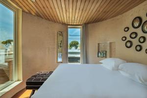 a bedroom with a white bed and a large window at La Villa Mauresque in Saint-Raphaël
