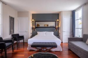a bedroom with a large white bed and a couch at La Villa Mauresque in Saint-Raphaël