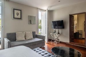 a living room with a couch and a tv at La Villa Mauresque in Saint-Raphaël