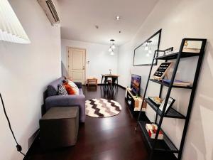 a living room with a couch and a book shelf at Gramercy Residences NEW! Tranquil 1BR Suite, 600mbps WIFI, Netflix & FREE Amenities in Manila