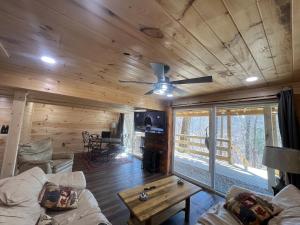 a living room with a couch and a ceiling fan at Cabin in the treetops! in Lancaster