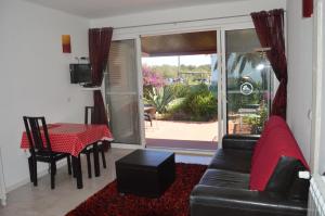 a living room with a black leather couch and a table at Tavira Vacations Apartments in Tavira