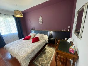 a bedroom with a bed with red pillows on it at La Belle Chaumière in Bretagne-de-Marsan +47 photos