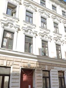 a white building with a red door and windows at Smart Luxury Apartment in Vienna l JOS25 in Vienna +4 photos