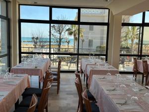 a room with tables and chairs with wine glasses at Hotel Alcazar in Rimini