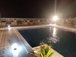 uma piscina à noite com luzes num edifício em OAsis du VoyAgeuR a peaceful appartement for stop over em Abidjan