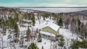 an aerial view of a house in the snow at Chalet Entre Ciel et Fleuve, SPA, 5 CH, 5 SDB in Petite-Rivière-Saint-François