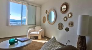 a living room with a table and a chair and mirrors at Port Saint-Tropez in Saint-Tropez