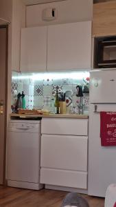a kitchen with white appliances and a refrigerator at P2 au pied des Pistes La Joue du Loup in Le Dévoluy