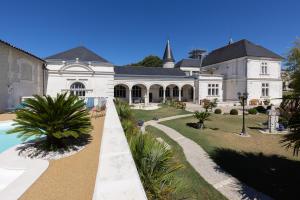 a large white house with a swimming pool in front of it at Château Pellisson in Cognac
