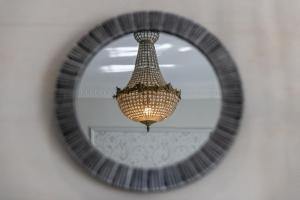a mirror hanging on a wall with a chandelier at Château Pellisson in Cognac