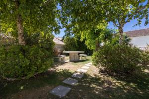 a picnic table in the middle of a yard with trees at Château Pellisson in Cognac