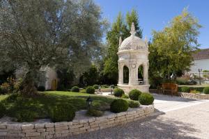 a gazebo in a garden with a stone wall at Château Pellisson in Cognac