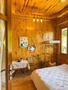 ein Schlafzimmer mit einem Bett und einem Tisch darin in der Unterkunft Đà Lạt 2019 homestay in Ấp Phước Thánh