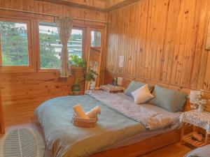 ein großes Bett in einem Zimmer mit Holzwänden in der Unterkunft Đà Lạt 2019 homestay in Ấp Phước Thánh + 8 Fotos
