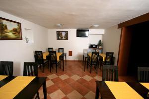 een eetkamer met tafels en stoelen en een televisie bij Privat Kohut in Štrba