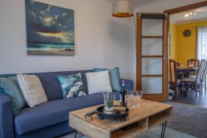 een woonkamer met een blauwe bank en een houten tafel bij Glasgow, spacious, 2 bed with parking in Garthamlock