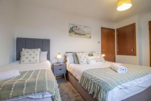 a bedroom with two beds and a nightstand between them at Ideal Contractor Stay 2-Bed Near Glasgow Fort in Garthamlock